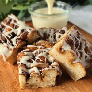 Gluten-free Cinnamon Roll Focaccia with icing drizzle and a bowl of icing