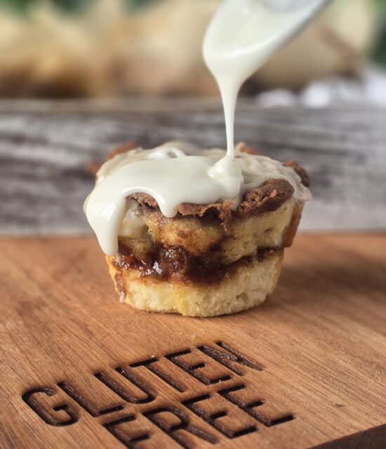 gluten free cinnamon roll muffin with icing being drizzled on top